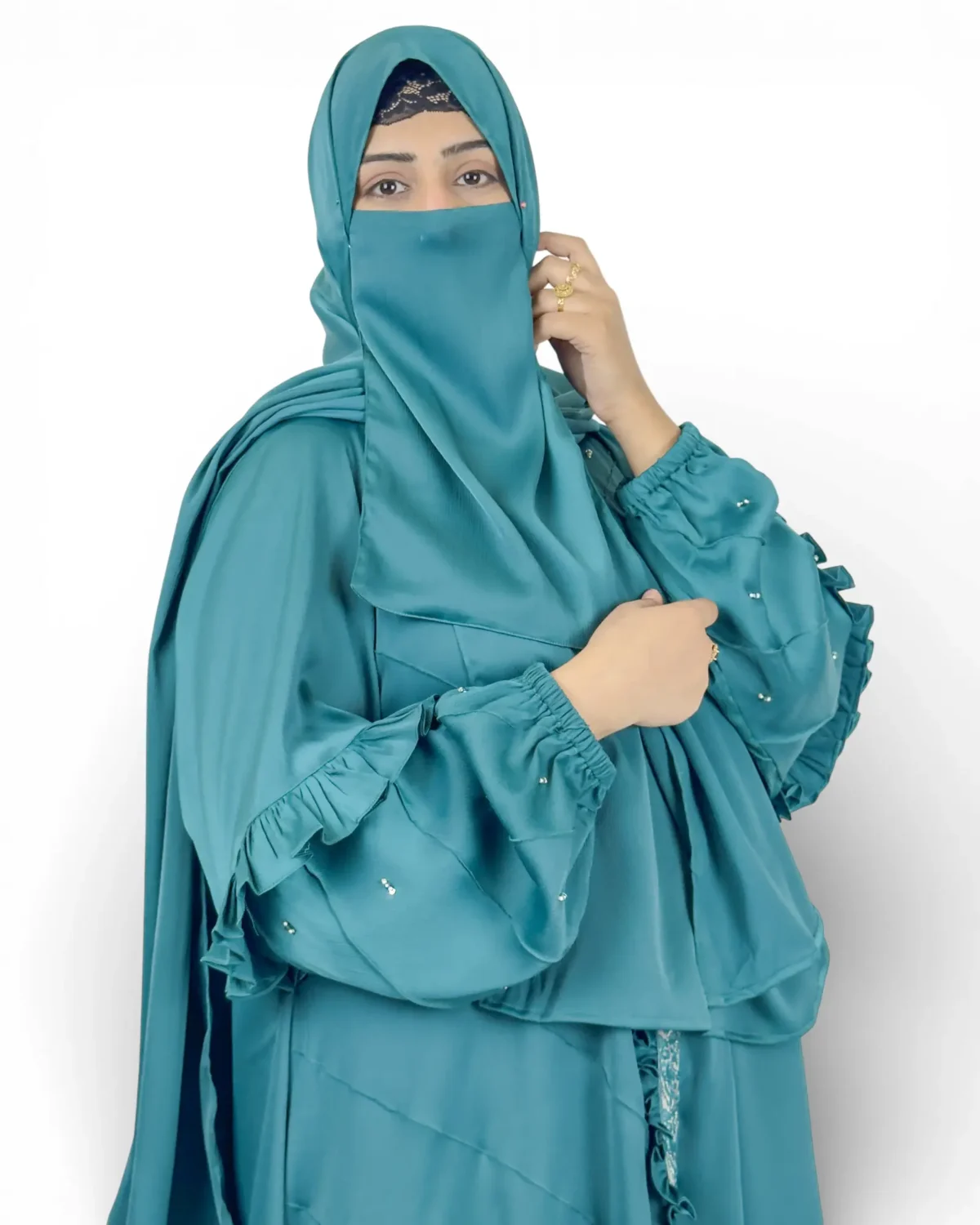 Ocean Lace teal abaya seated pose showcasing full draped silhouette