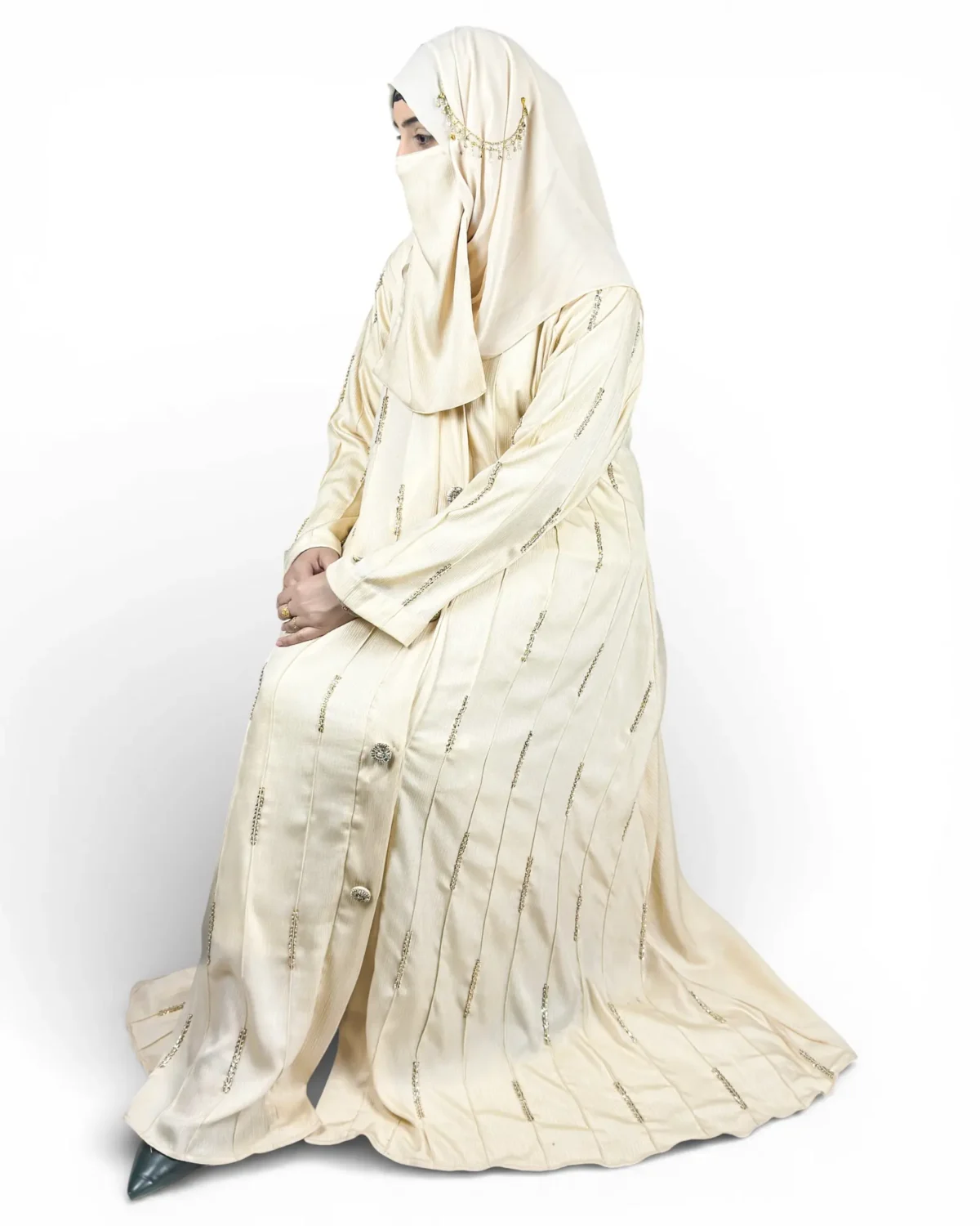 Royal Ivory ivory abaya angled view highlighting decorative buttons running down front panel