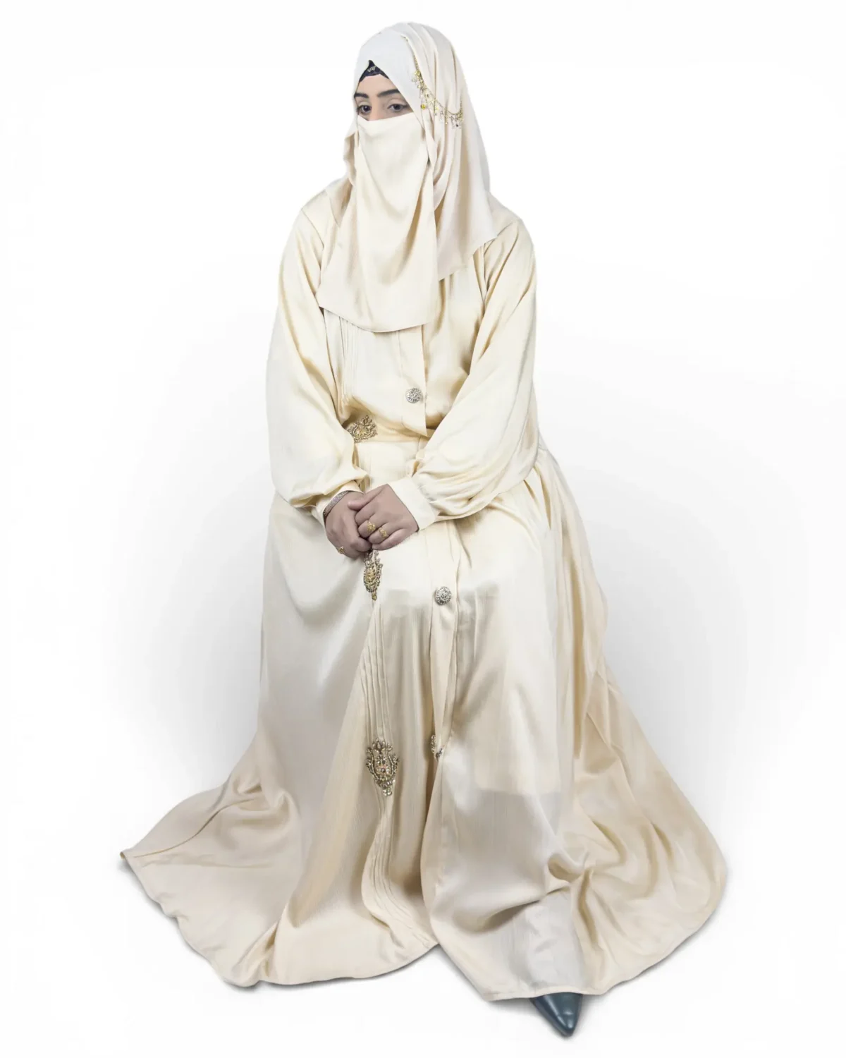 The Vanilla cream abaya showing ornate jeweled brooch appliqués running down front panel