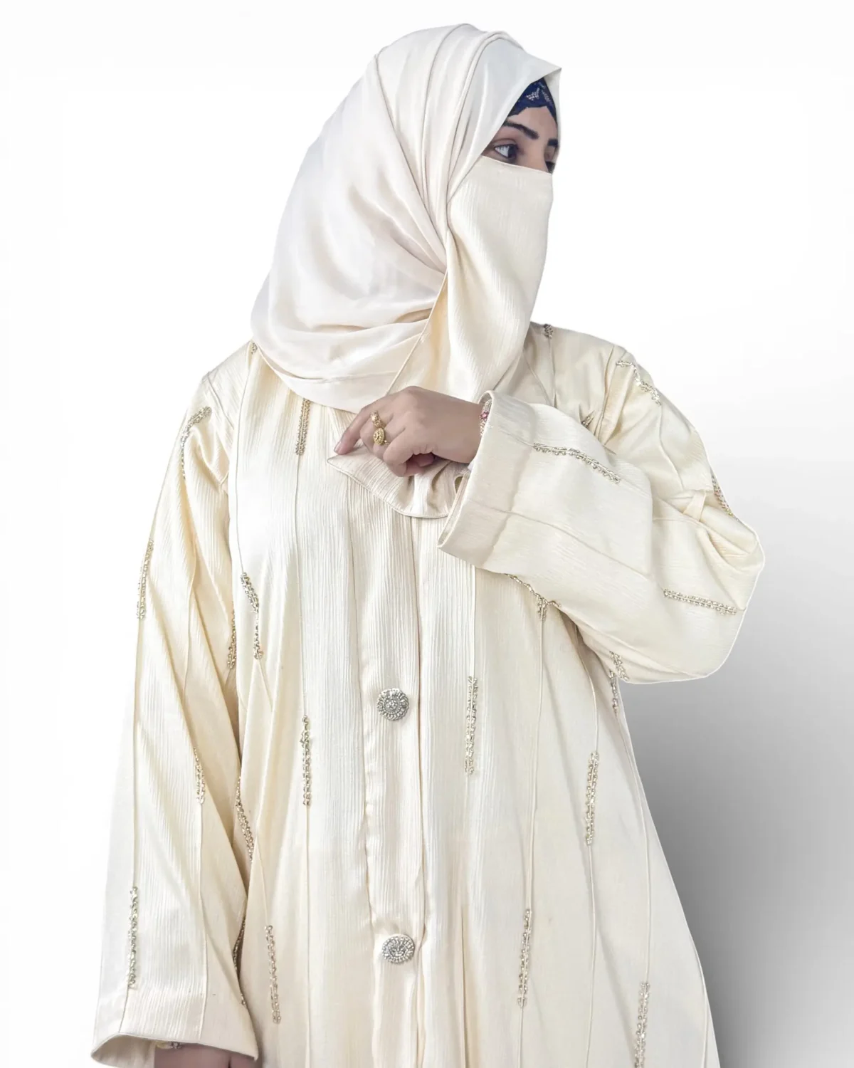 Royal Ivory abaya close-up showing gold and silver chain embroidered dash motifs on fabric