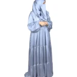 Blue Tiers dusty blue abaya side profile view with softly tiered high-sheen satin skirt