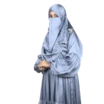 Blue Tiers dusty blue abaya front three-quarter view with softly tiered high-sheen satin skirt