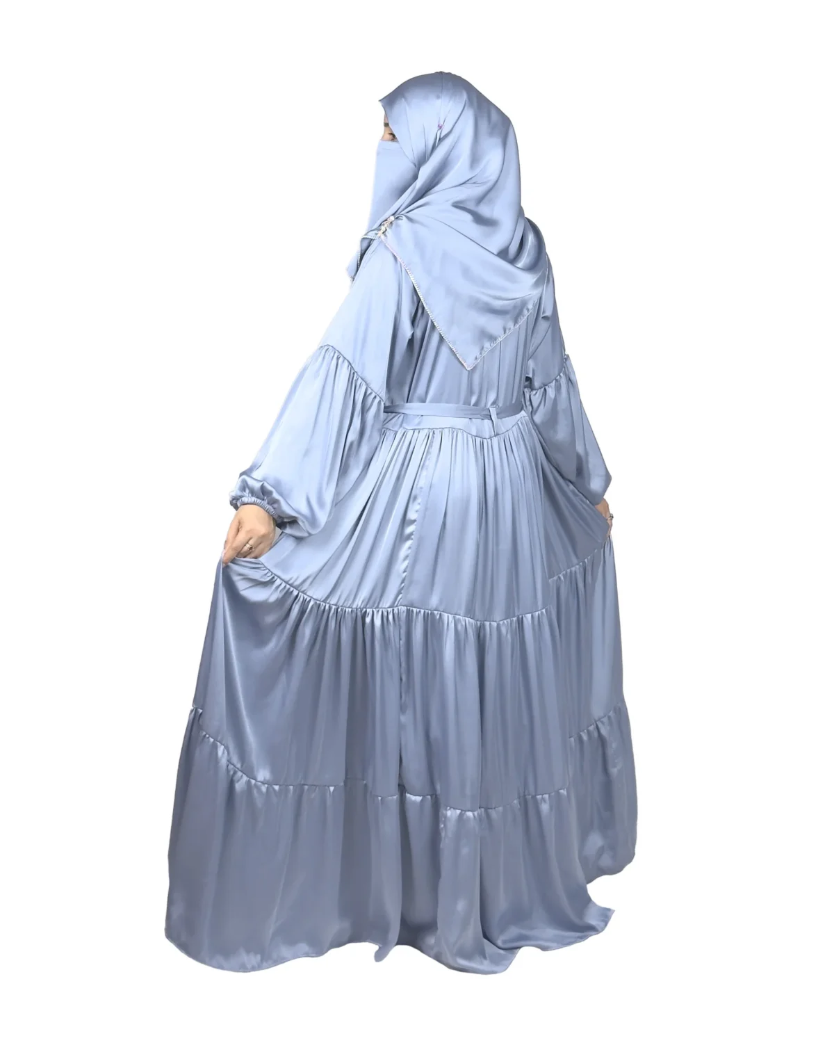 Blue Tiers dusty blue abaya front three-quarter view with softly tiered high-sheen satin skirt