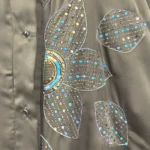 Copper Lily copper / warm dark brown abaya close-up of the oversized sequinned flower appliqué