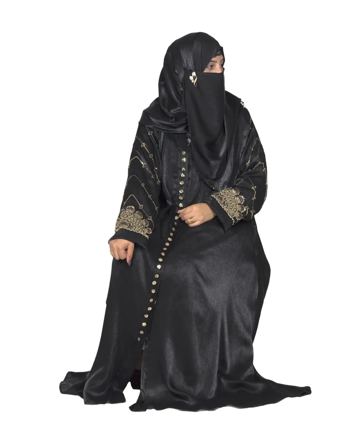 Onyx Gold black abaya front three-quarter view with gold-and-black beaded cuffs and sequin-flower buttons