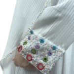 Pearl Drape white abaya close-up of the multicolour beaded rosettes on the cuff